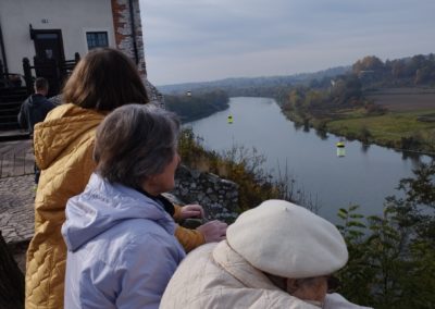 Zdjęcie trzech kobiet zza pleców, które spoglądają na rzekę.]